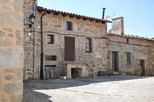 Steinernes Haus mit kleinen Fenstern und Türen in Medinilla, Ávila.