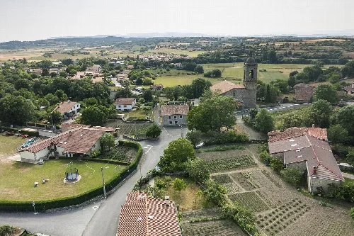 Luftaufnahme von Häusern, Gärten und einem Glockenturm in Ondátegui, Álava.