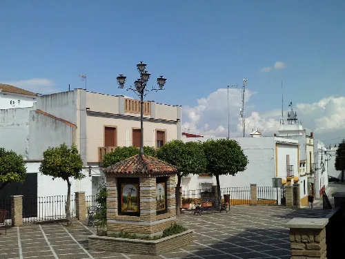 Square with trees, benches, and a kiosk in Almensilla.