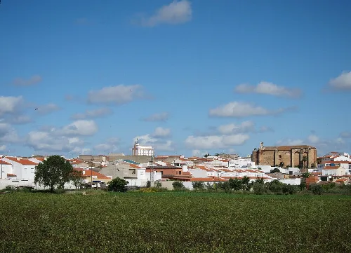 Landschaft von La Albuera mit weißen Häusern und einem alten Gebäude im Hintergrund.