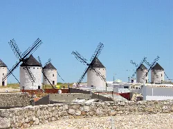 Mehrere weiße Windmühlen mit schwarzen Flügeln in einer Landschaft von Campo de Criptana.