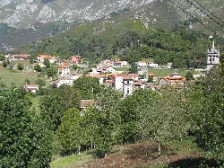 Pueblo de Alles en Peñamellera Alta con casas y montañas de fondo.
