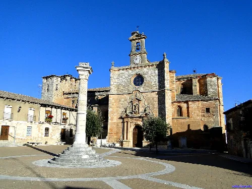Church and square in Mahamud, Burgos, with monument in the center and old buildings.
