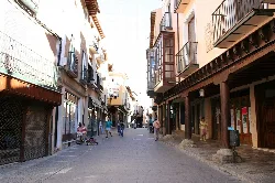Straße mit Arkaden, Geschäften und Fußgängern in Medina de Rioseco.