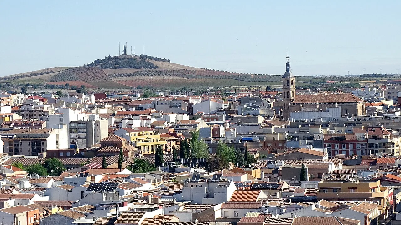 Vista de la ciudad de Valdepeñas con edificios y una colina en el fondo.