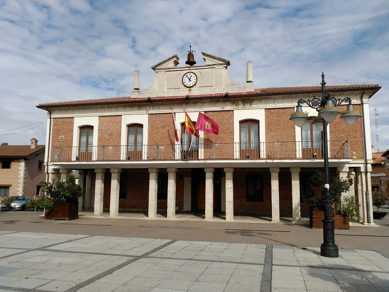 Edificio de la casa consistorial con banderas y columnas en la fachada.