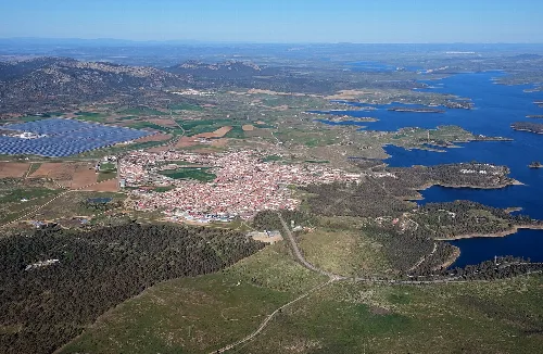 Luftaufnahme eines Ortes neben einem Stausee und ländlichen Gebieten.