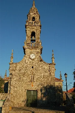 Turm der Pfarrkirche St. Michael in Carballedo mit Uhr und Glockenturm.