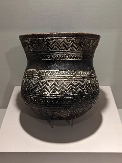 Cuenco negro con decoraciones geométricas en blanco y líneas horizontales.