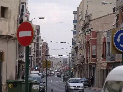 Ansicht der Hauptstraße von Almusafes mit Gebäuden und Autos.
