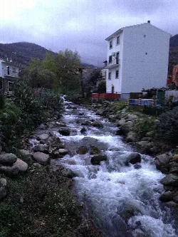 Fluss mit Steinen und Häusern in Gargantilla.