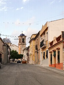 Street with buildings and a church in the background in Campo de Mirra.