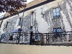 Edificio en Cedillo con mural de líneas blancas y negras.