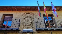 Facade of Elciego's town hall with coat of arms and flags.