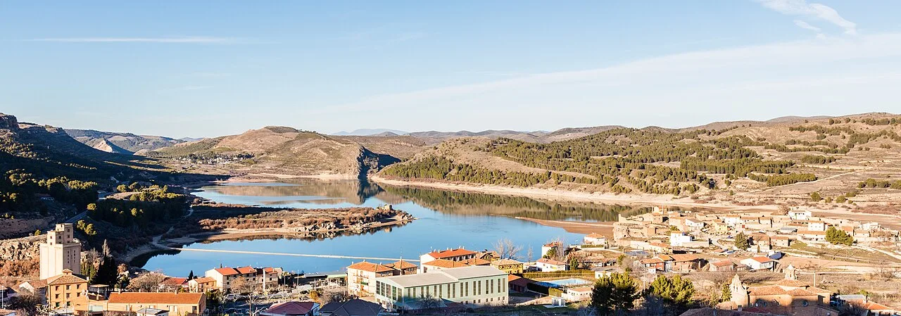 Landscape of Nuévalos with reservoir and hills in the background.