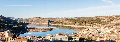 Landscape of Nuévalos with reservoir and hills in the background.