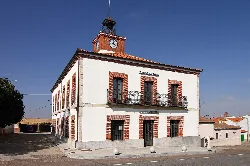 Edificio del ayuntamiento de Mozárbez con reloj y balcón en la fachada.