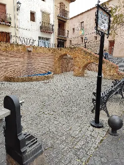 Plaza del Horno with a water well and stone arch in Geldo.
