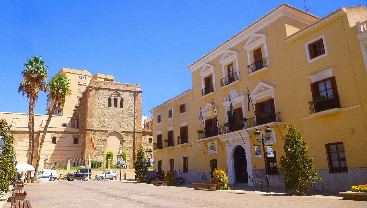 Plaza de España in Motril with yellow building and old tower.