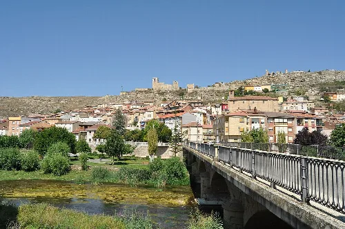 Bridge over the river with houses and a castle on the hill.