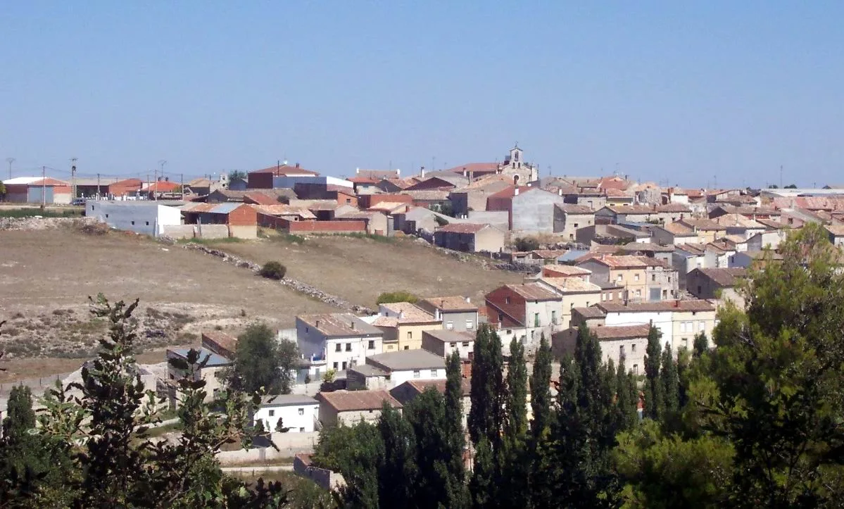Paisaje de Hérmedes de Cerrato con casas y colinas.