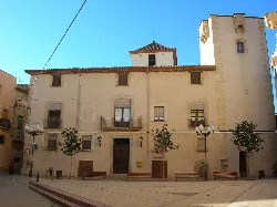 Town hall building in Vinyols i els Arcs with stone facade and barred windows.