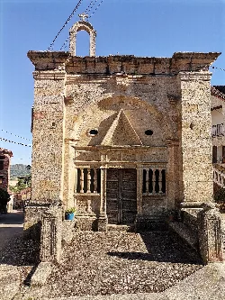 Stone facade of the Cristo Hermitage with decorated portal and small bell tower.