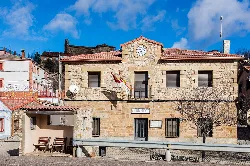 Town hall building with clock and flag in Anquela del Ducado.
