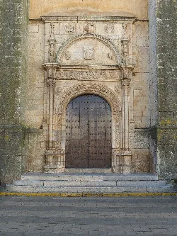 Wooden door with arches and stone details at the church in Los Santos de Maimona.