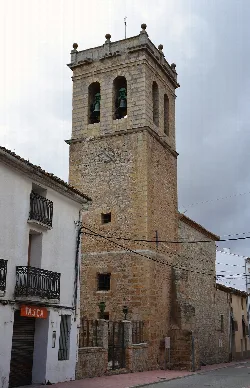 Stone bell tower with clock and bells in Barracas.