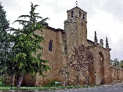 Church of the Holy Cross in Bañares, La Rioja, with tower and trees.