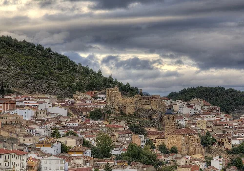 Vista de un pueblo en una colina con casas blancas y una iglesia antigua.