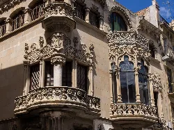 Fassade eines Gebäudes in Reus mit ornamentalen Details und dekorativen Balkonen.