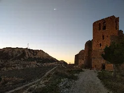 Kirche El Cristo in Caparroso, Navarra, mit Hügeln und klarem Himmel.