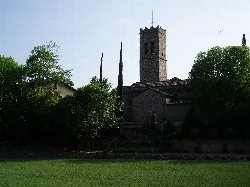 Torre de piedra y árboles en la iglesia de Santa María en Paláu Solitar y Plegamans.