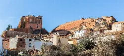 Houses and a castle on the hilltop in Ibdes, Zaragoza.