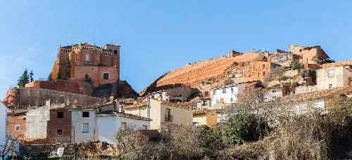 Houses and a castle on the hilltop in Ibdes, Zaragoza.