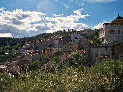 Vista de casas en una ladera con cielo nublado en El Pardal, Molinicos.