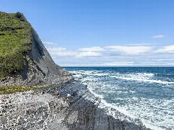 Deva-Küste mit Flysch-Formationen und Meereswellen.