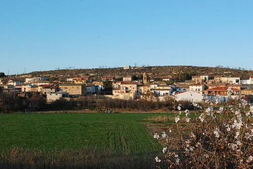 Front view of Lazagurría with houses on the hill and green field.