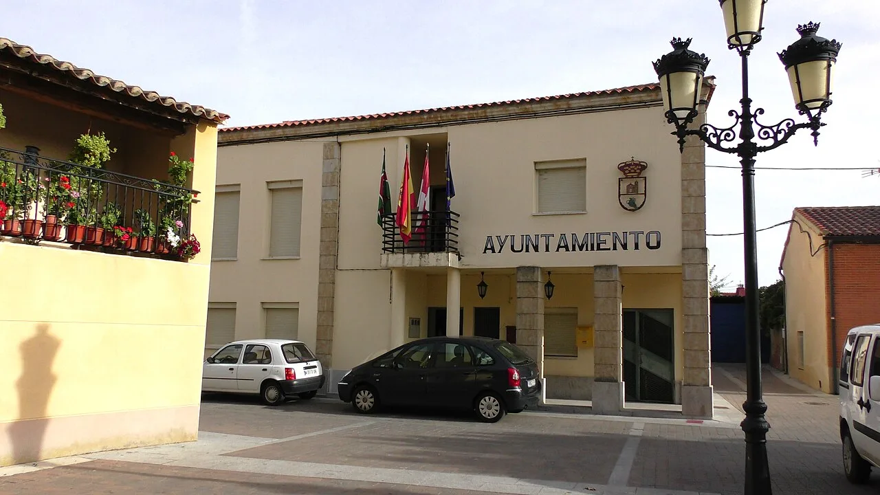 Rathaus von Arcenillas mit Flaggen und Schild.