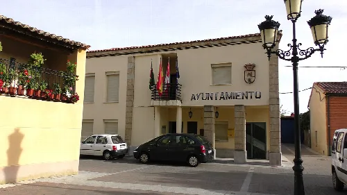 Rathaus von Arcenillas mit Flaggen und Schild.