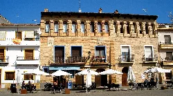 Plaza con terrazas y un edificio histórico en La Almunia de Doña Godina.