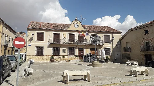 Building with clock and flags on the facade of the town hall.