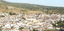 Vista aérea de un pueblo con tejados de tejas rojas y calles estrechas.