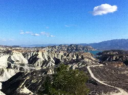 Paisaje árido con formaciones rocosas y embalse en el fondo en Murcia