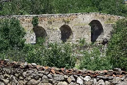 Steinbrücke mit Bögen in einer grünen Umgebung in Puente del Congosto.