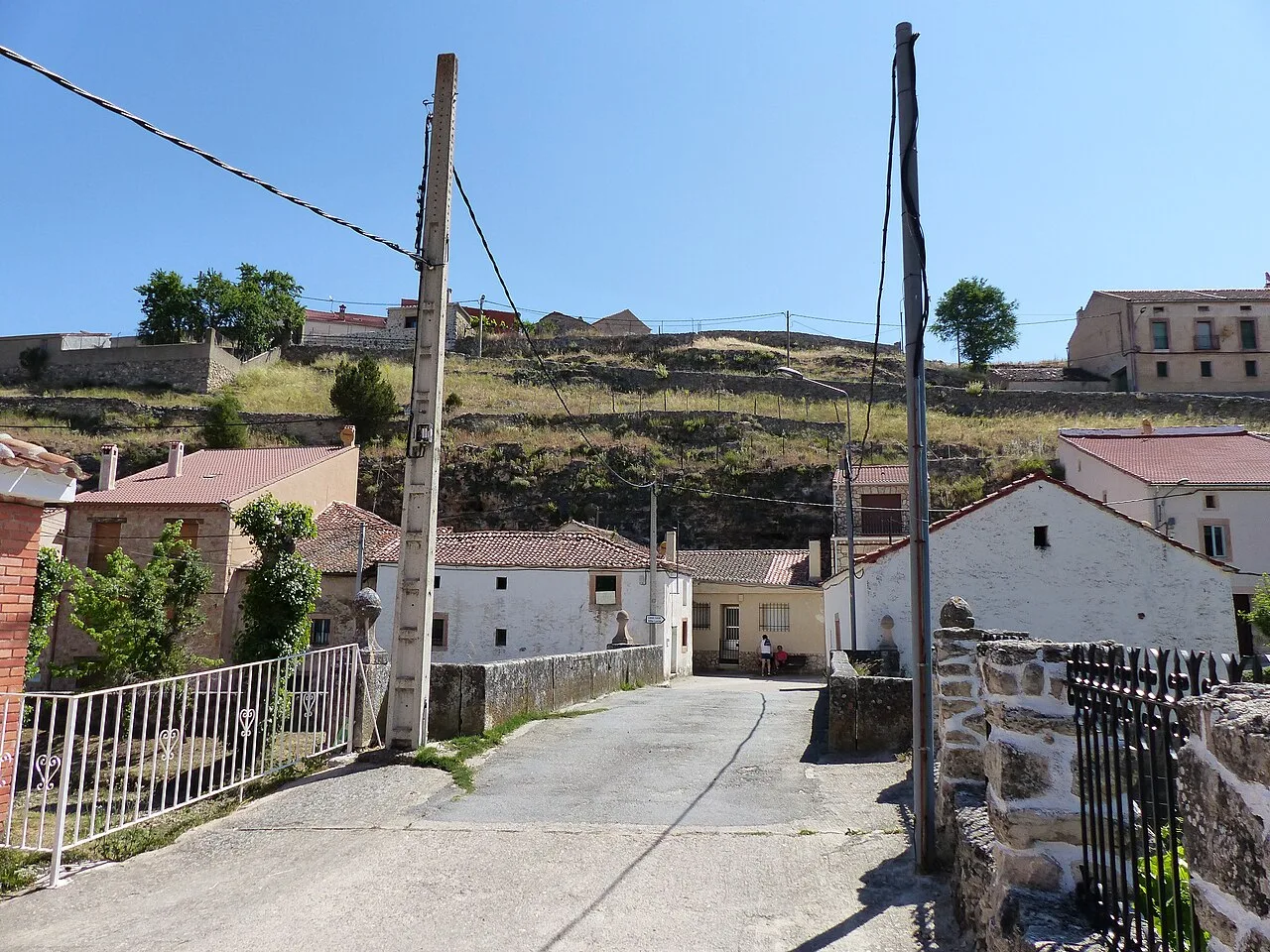 Calles y casas en Castroserna de Abajo con colinas en el fondo.