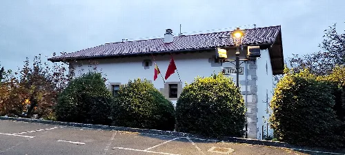 Iza Rathaus mit Flaggen und Büschen vor dem Gebäude.