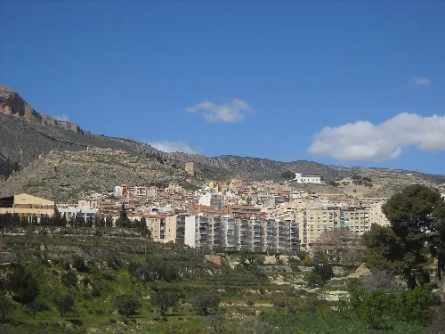 Hillside town with buildings and mountains in the background